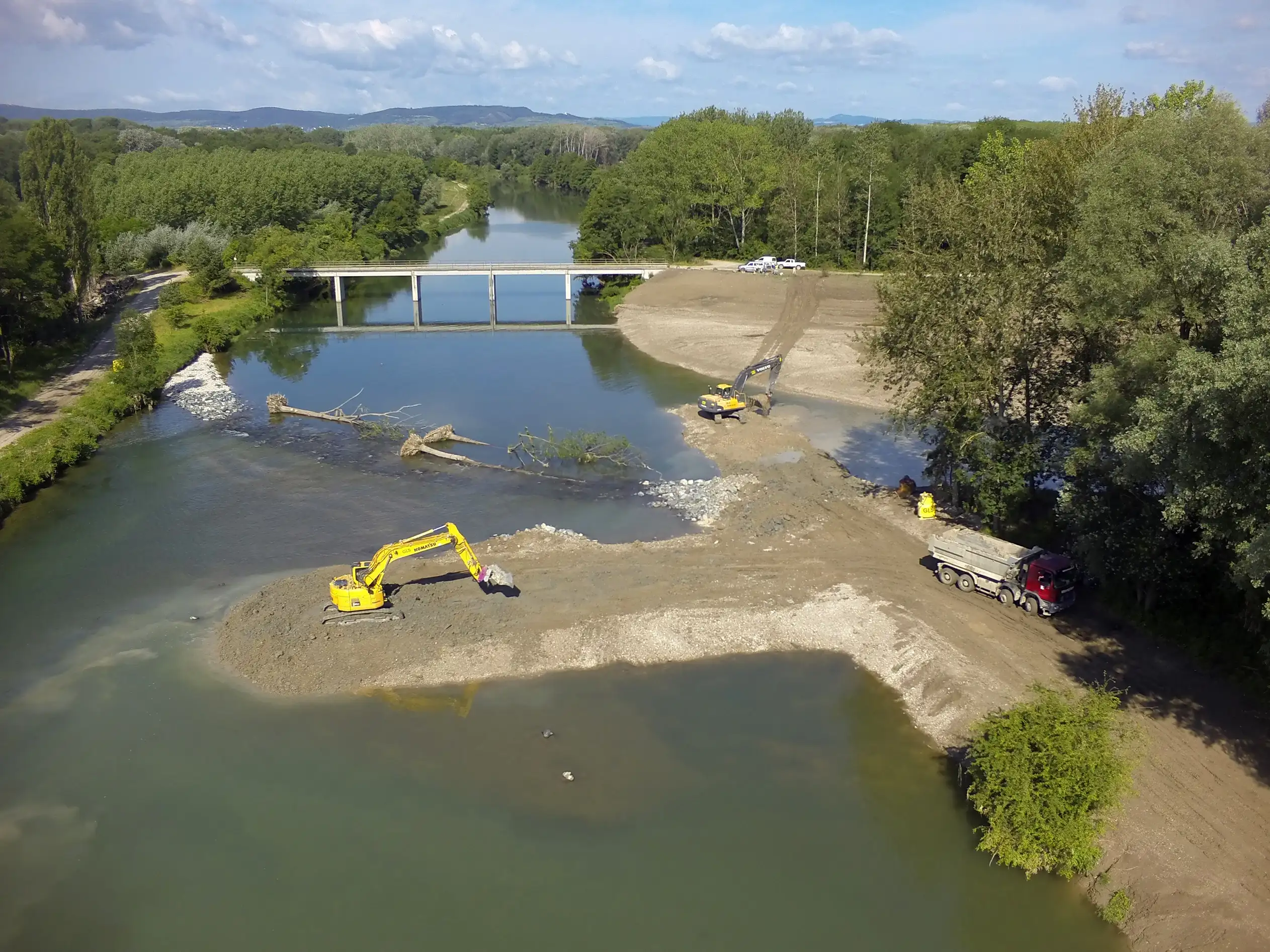 Blick von oben auf die Baustelle LIFE+ Traisen im Jahr 2014. Ein Bagger ist im Einsatz. Im Hintergrund ist die Feldwegbrücke zu sehen.